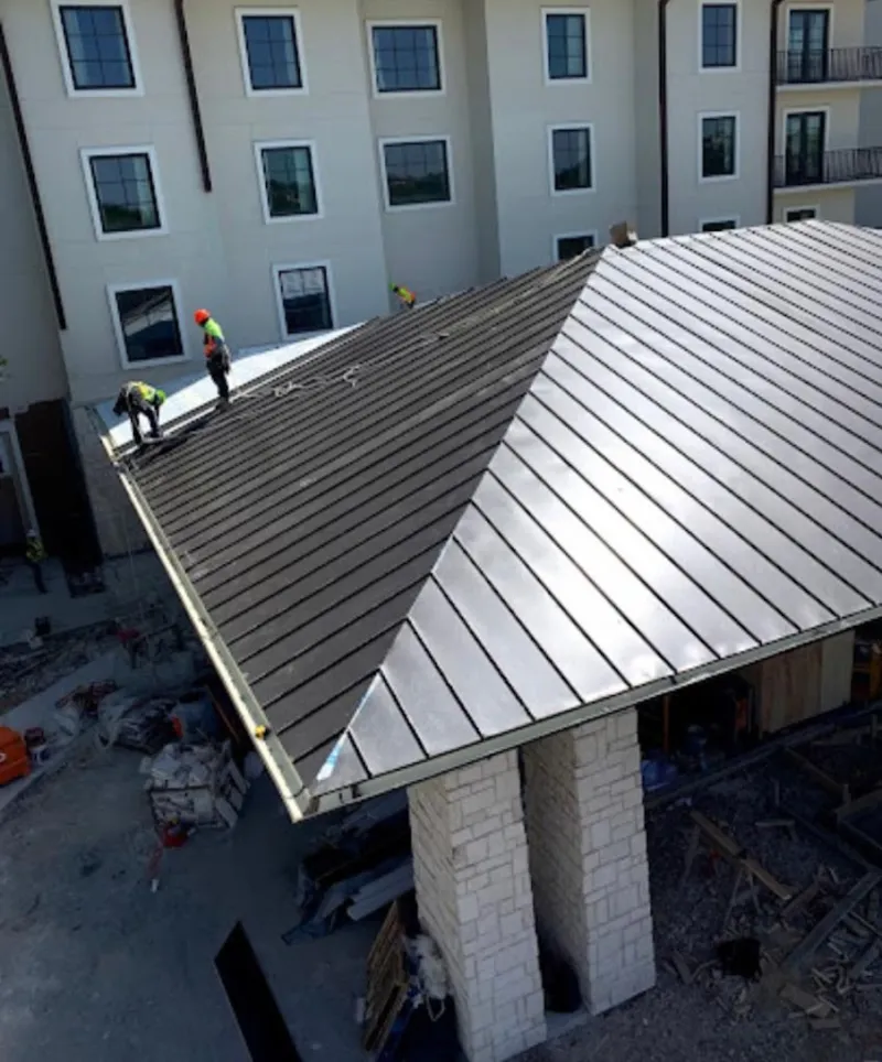 Crew installing standing seam metal roof panels on a commercial project in Washington